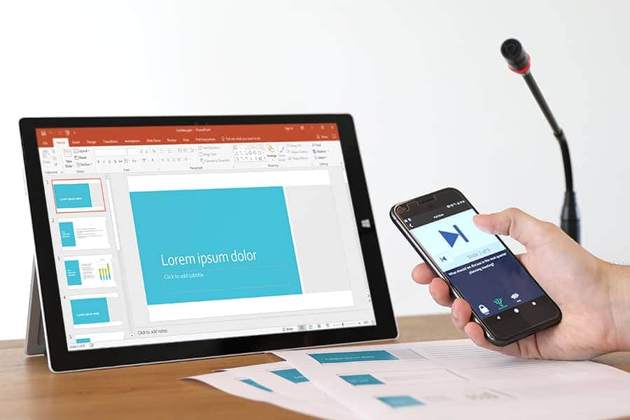 tablet on desk and person holding phone